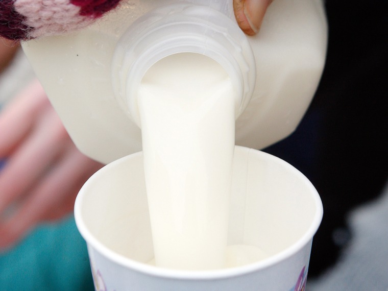 A woman pours a cup of raw milk for a child during a protest in Chicago, Illinois, December 8, 2011. The U.S. Food and Drug Administration prohibits i...