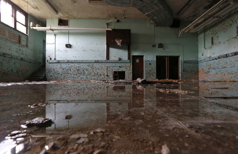 Water from a leaking pipe covers the gymnasium floor at the Caroline Crosman School in Detroit on Oct. 29.