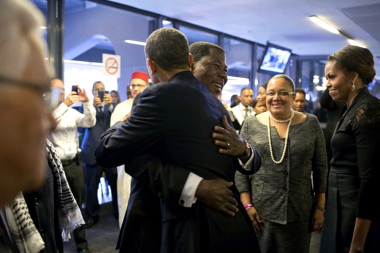 President Yayi Boni of Benin welcomes President Obama as he arrives at the soccer stadium for the Nelson Mandela memorial service.