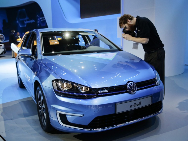Paul Schroder takes pictures of the new Volkswagen e-Golf electric vehicle at the Los Angeles Auto Show on Wednesday, Nov. 20, 2013, in Los Angeles. (...