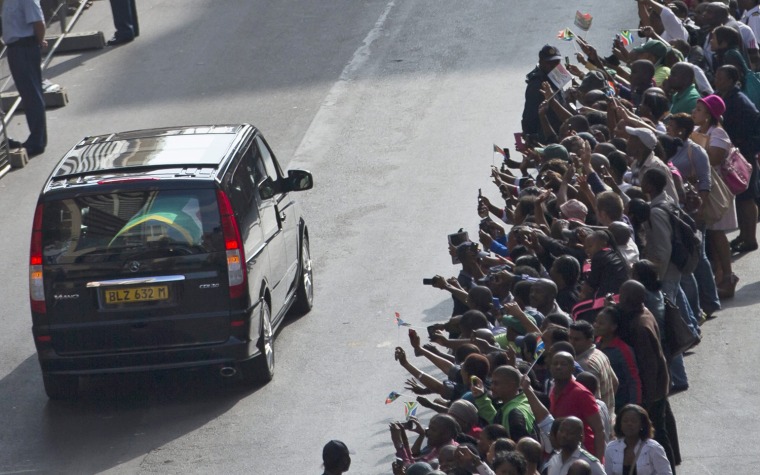 The hearse carrying the body of late South African president Nelson Mandela, whose coffin is wrapped in a flag, drives down Mandela Street to the Union Building in Pretoria, South Africa, on Thursday. The body will lie in state at the seat of the government for three days.