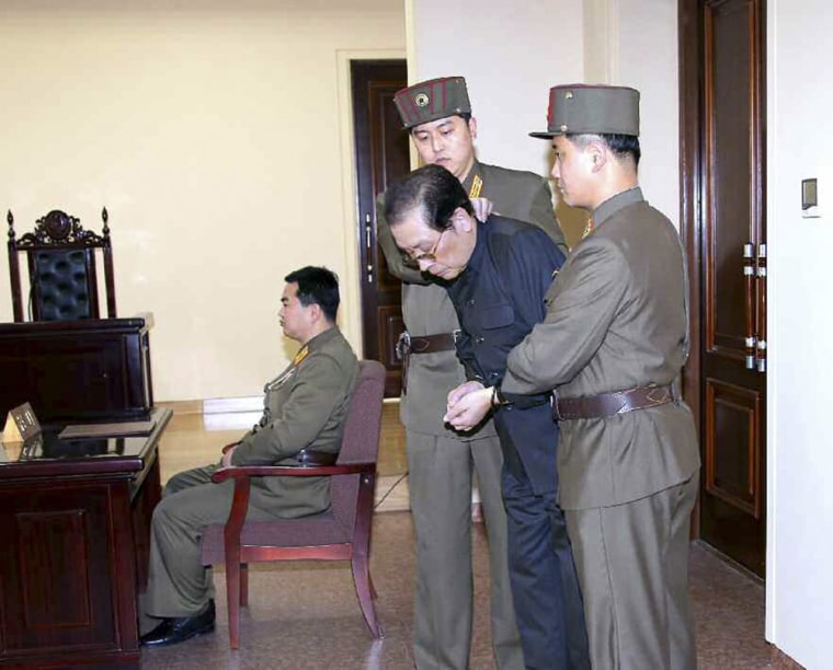 Jang Song Thaek, with his hands tied with a rope, is dragged into court by uniformed personnel in this picture published in a North Korean newspaper.