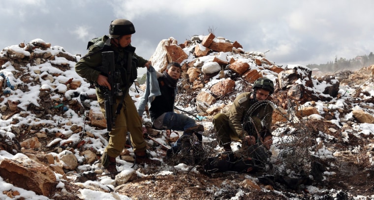 Israeli soldiers arrest two Palestinian boys near Nablus in the West Bank on Dec. 12. There were clashes after Palestinians reportedly tried to reach the al-Tour area, near the Jewish settlement of Brakha, for a snowball fight.