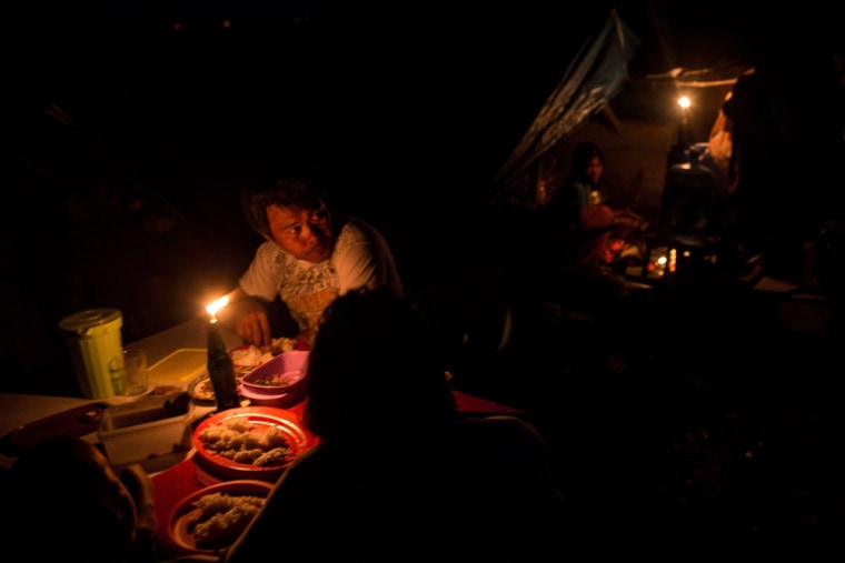 A family eats dinner by candle light in a destroyed area of Tacloban City on Nov. 18, 2013 in Leyte, Philippines.