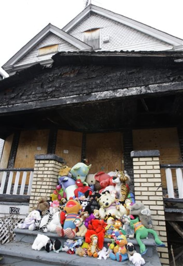 A February 2012 file photo shows stuffed animals left as a memorial on the steps of the burned-out house where a woman and eight people died in Cleveland in 2005.