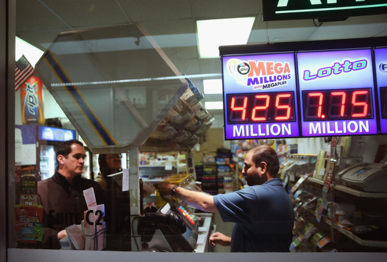 A clerk sells Mega Millions lottery tickets at a convenience store in Chicago on Friday.