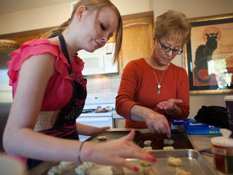 Davis helps her granddaugher, Hunter Hill, 15, bake holiday cookies at her home in Mesa, Ariz.