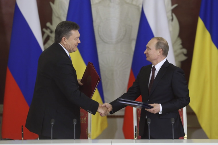 Russia's President Vladimir Putin (right) and his Ukrainian counterpart Viktor Yanukovich shake hands on Tuesday. Russia has agreed to resume oil supplies to a refinery in Ukraine, traders said, in a sign Moscow is ready to reward the country's president for spurning a trade deal with Europe in favor of ties with its former Soviet master.