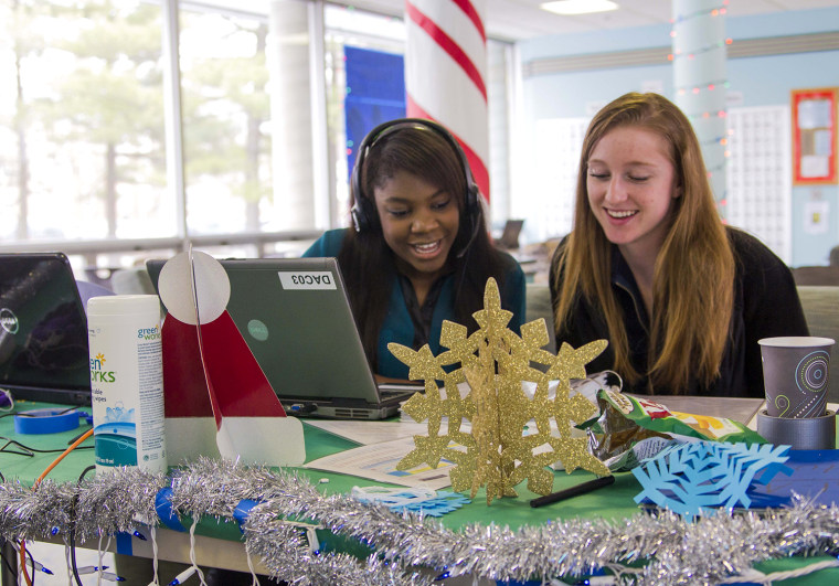 University of Illinois students Pauline Chitamdo, left, and Patti Grzyb sing to callers as part of the annual Dial-A-Carol program in Champaign, Ill. The student-run project is a hotline of sorts for people who prefer their holiday carols sung live by amateurs.
