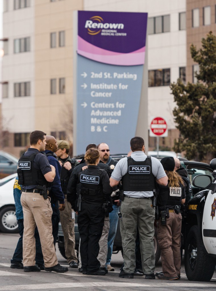 Officers gather in front of the Renown Medical Center after a lone gunman shot and killed a person and injured two others before killing himself on Tuesday.