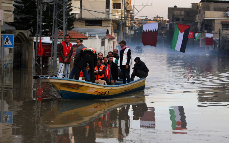 People are evacuated from their homes in a boat in a flooded area of Gaza City on Dec. 17.