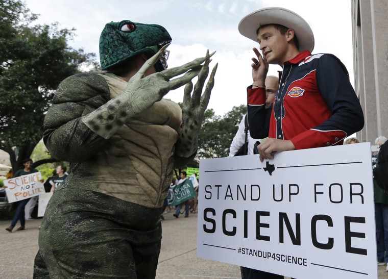 Dressed as T-Rex, Sandra Calderon talks with Nick Savelli prior to a State Board of Education public hearing on proposed new science textbooks., on Sept. 17, 2013, in Austin, Texas.