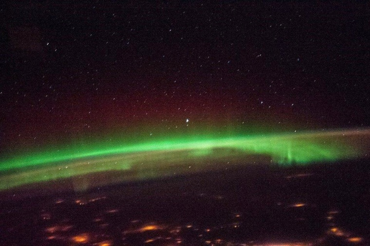 A Dec. 6 image from the International Space Station shows auroral lights below, with a reddish glow on top of the brighter greenish glow.