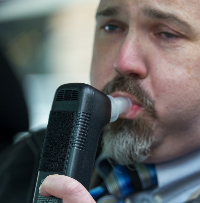 Bill Chastain, state director with LifeSafer, demonstrates a breath alcohol ignition interlock device during a