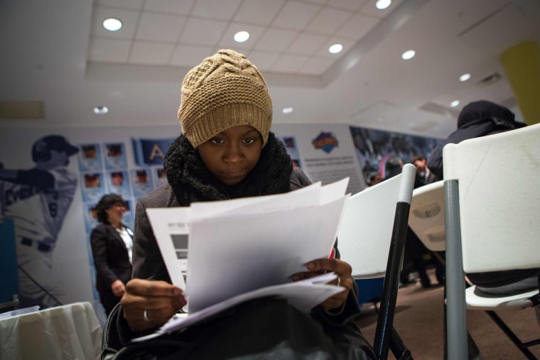 A woman fills out paperwork at a job training and resource fair at Coney Island in New York, Dec. 11, 2013.