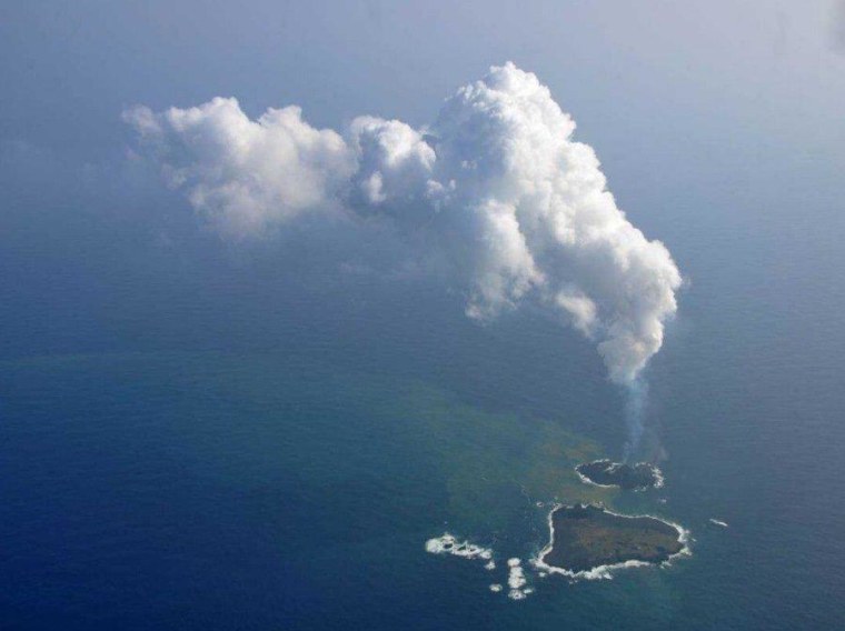 Clouds of steam and gas rise from Niijima on Dec. 13, in an aerial photograph from the Japan Coast Guard. Nishino-shima is nearby.