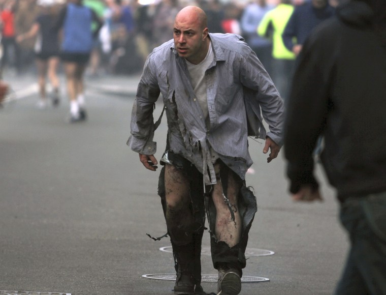 In this photo provided by The Daily Free Press and photographer Kenshin Okubo, Boston Marathon bombing victim James Costello staggers away in his torn...