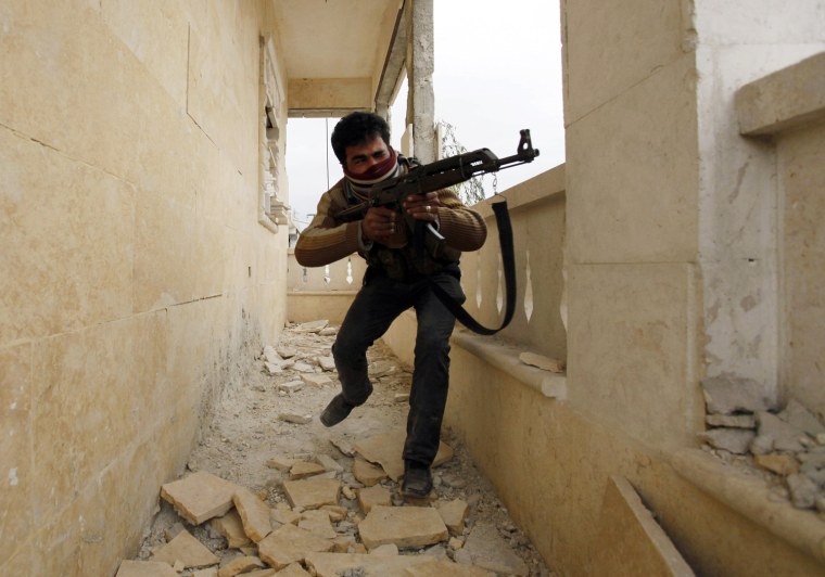 A Free Syrian Army fighter aims his weapon as he takes up a position in Aleppo's Sheikh Saeed neighborhood on Dec. 4, 2013.