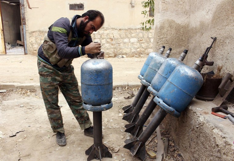 A fighter from the Tawhid Brigade, which operates under the Free Syrian Army, prepares homemade rockets to be thrown towards the 80th Brigade base in Aleppo, currently controlled by forces loyal to Syria's President Bashar al-Assad, on Nov. 11, 2013.