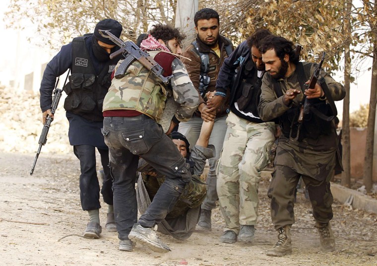 Free Syrian Army fighters carry a fellow fighter who was wounded during clashes with forces loyal to Syria's President Bashar al-Assad, near Base 80 close to Aleppo International Airport, on Nov. 8, 2013.