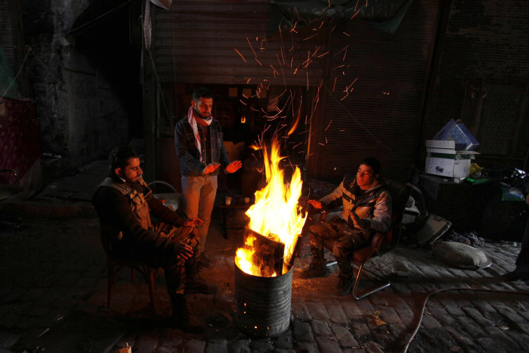 Free Syrian Army fighters warm up by a fire in Old Aleppo, on Dec. 15, 2013.