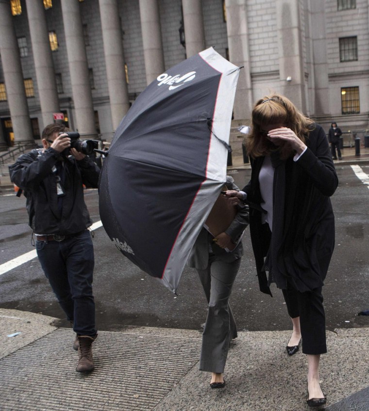 Ingrid Lederhaas-Okun (right), a former executive at Tiffany & Co., covers her face as she and her attorney leave federal court in New York on Monday.