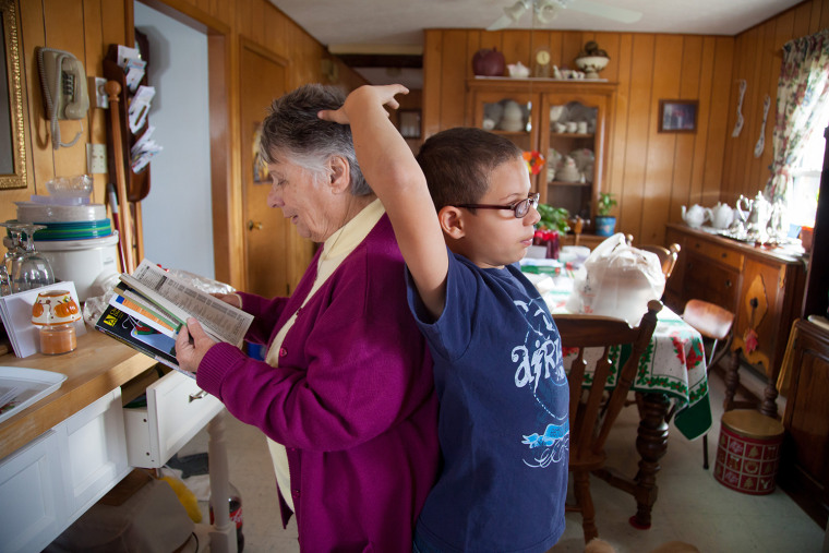 Ector Taylor, 9, checks to see how he measures up to his grandmother, who often worries if she can provide enough for three growing boys.