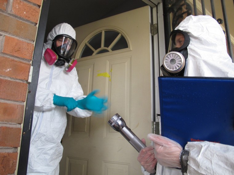 Certified industrial hygienist Gary Siebenschuh, left, and assistant Courtney Van Stolk prepare to enter a house that was once used as a clandestine methamphetamine lab in Memphis, Tenn., on Nov. 25. The house was placed under quarantine after a Nov. 6 fire that police said was caused by a meth lab that exploded in the attic of the house. Siebenschuh and Van Stolk were hired by the homeowner to test the home for meth residue.