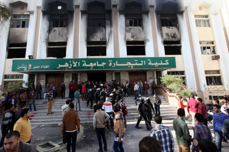 Egyptian students stand outside a faculty building at Cairo's Al-Azhar University on Sunday, one day after students supporters of the Muslim Brotherhood set it on fire in the latest unrest to rock the country. Separately, four soldiers were wounded in a bomb attack.