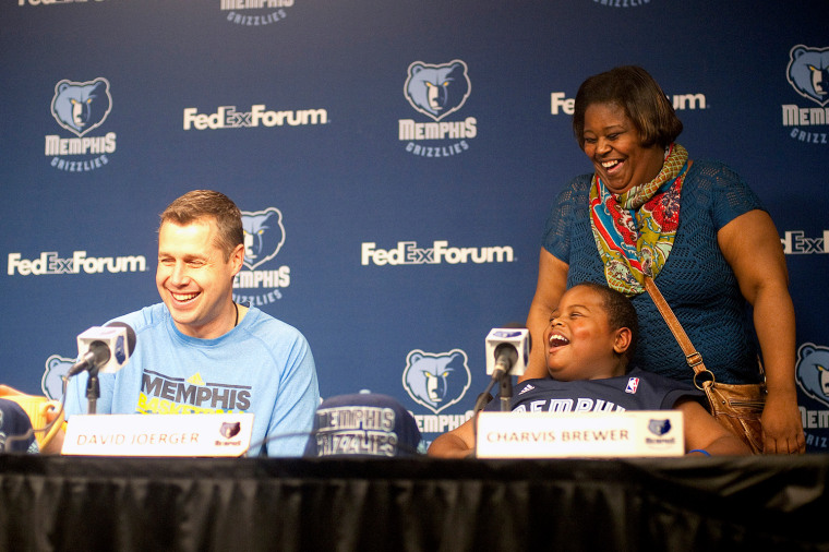David Joerger, head coach for the Memphis Grizzlies, speaks at a press conference with 8-year-old Charvis Brewer on Sunday. Charvis' mom, Colissa Brewer, laughs happily behind her son.