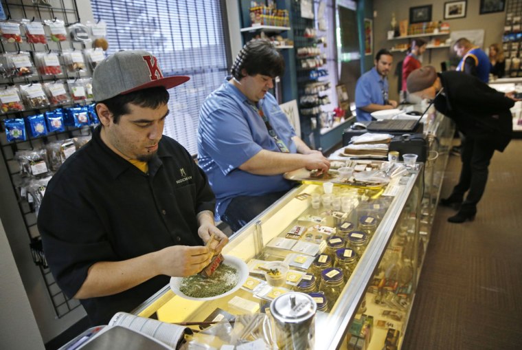 Employees roll joints behind the sales counter at Medicine Man marijuana dispensary, which is among the first batch of Denver businesses to receive their licenses allowing them to legally sell recreational marijuana beginning Jan. 1. 2014.