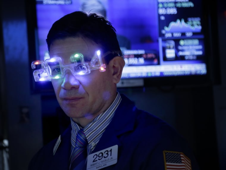 A trader wears glasses celebrating the new year while working on the floor at the New York Stock Exchange in New York, Tuesday, Dec. 31, 2013. (AP Ph...