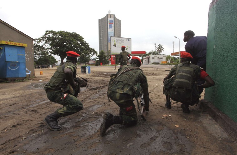Congolese security officers position themselves as they secure the street near the state television headquarters in the capital Kinshasa on Monday.