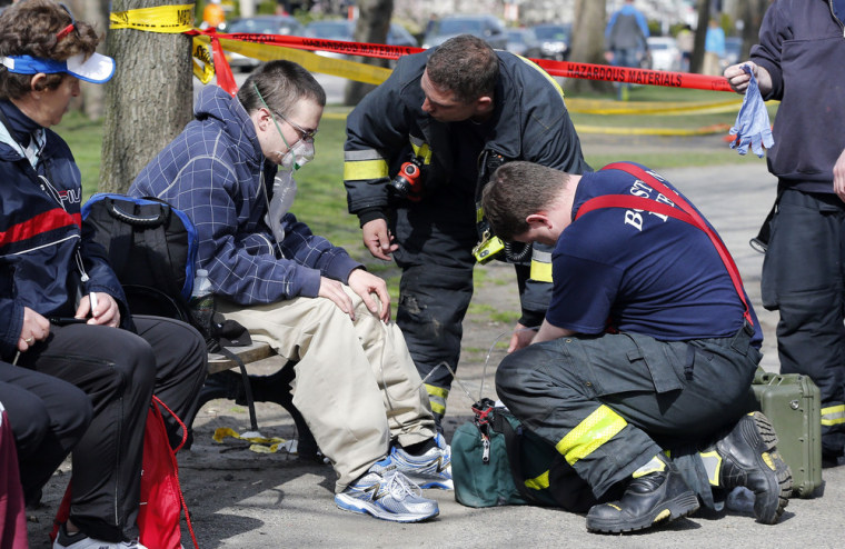 Firefighters tend to a man following an explosion at the finish line of the Boston Marathon.
