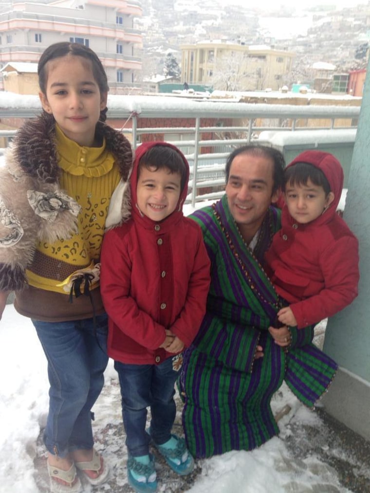 Kabul resident Jala Mahmoodi 42, celebrates the first snowfall with his children on Monday, Dec. 30, 2013.