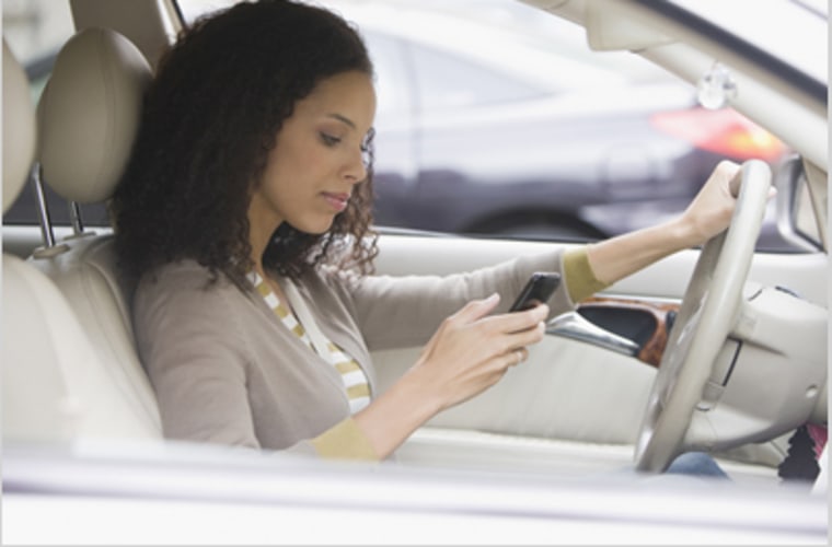 Woman texting behind wheel.
