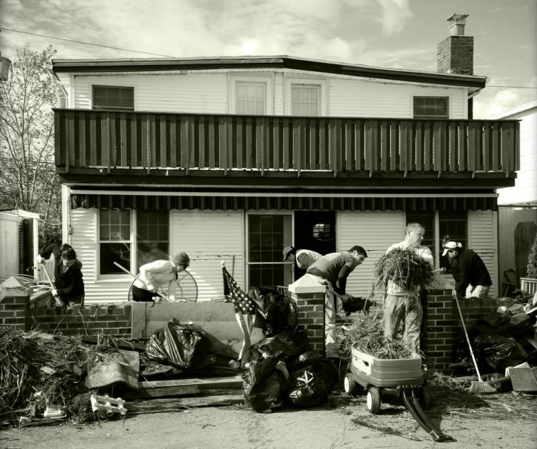 Veets Pawlowicz, second from right, is aided by a gang of family, friends and even volunteering strangers as they clean up his mother-in-law Kathleen Campbell's house on Nov. 2, 2012, in Breezy Point.