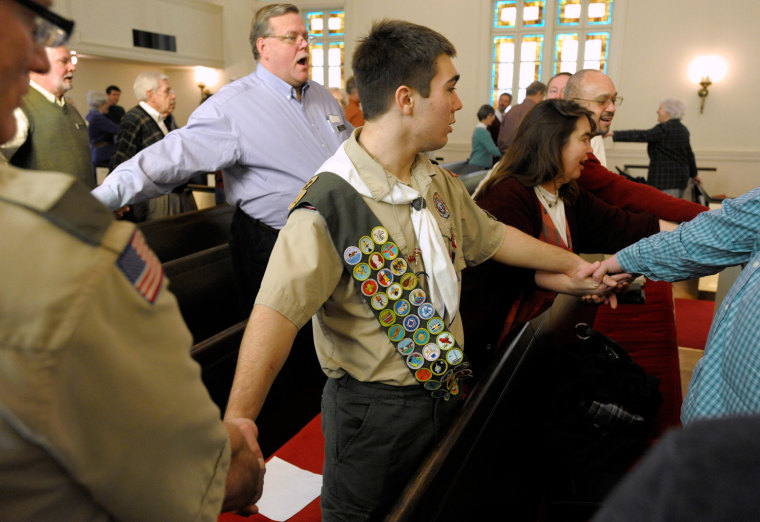Eagle Scout Addison Jones, 15, holds hands during a hymn with parishioners of the Country Club Congregational United Church of Christ in Kansas City, Mo., on