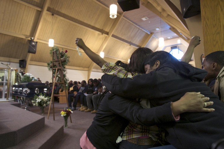 Tahitah Myles raises her hands as she is comforted during the funeral of Ronnie Chambers, 33, the father of her son and a victim of gun violence, in Chicago Feb 4.