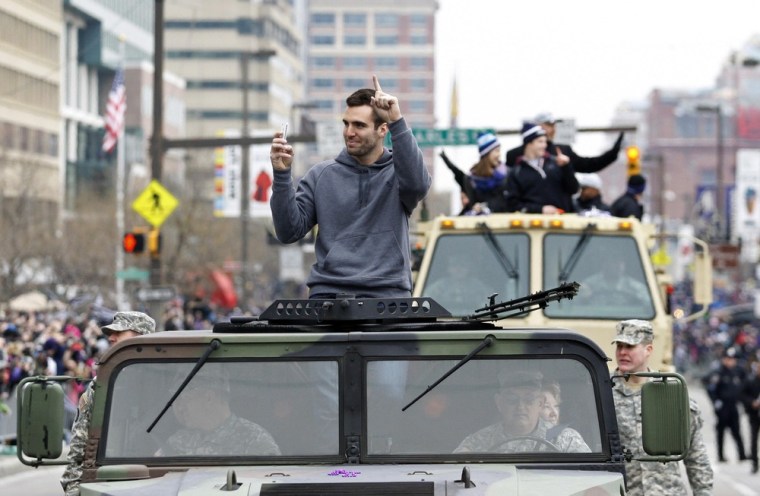 Ravens quarterback and Super Bowl MVP Joe Flacco waves to the crowd gathered on the team's victory parade route in Baltimore.