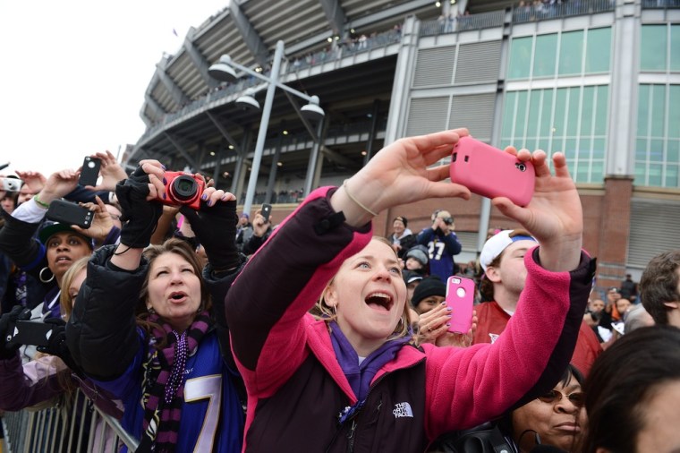 Fans take pictures of The Vince Lombardi Trophy during the Ravens Super Bowl victory parade in Baltimore.