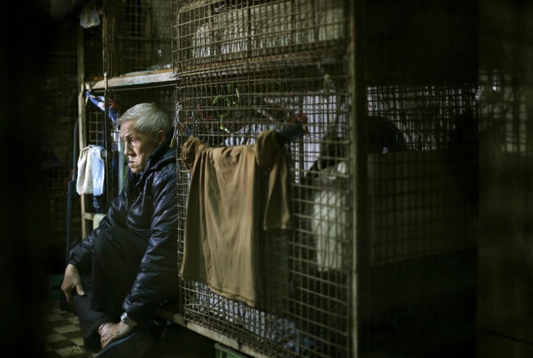 77-year-old Yeung Ying Biu sits inside his cage home on Jan. 25, 2013.