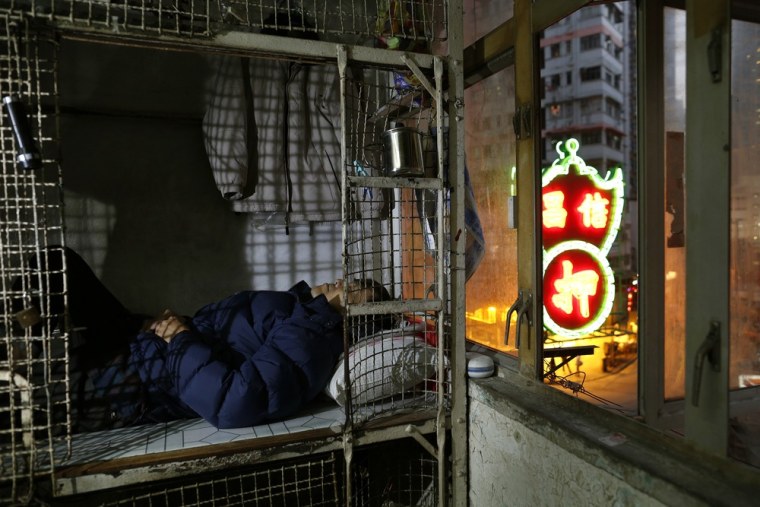 62-year-old Cheng Man Wai lies in the 16 square foot cage that he calls home, in Hong Kong on Jan. 25, 2013.