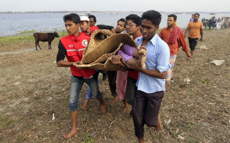 Rescue workers carry the body of a victim ashore on the banks of the Meghna River at Munshiganj on Feb. 8, 2013.