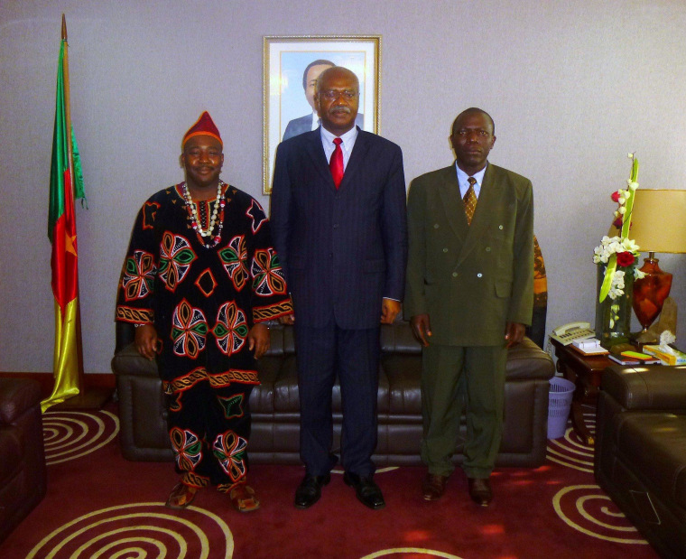 William Holland, left, gets his picture taken with Cameroonian Prime Minister Philemon Yunji Yang and Emmanuel Motika, a physics teacher from the Cameroonian town of Bamenda who is an extremely distant relative of Holland.