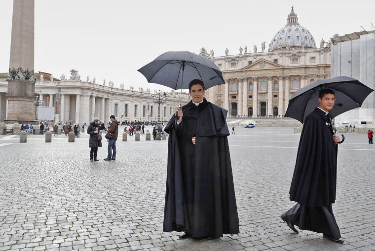 Two priests walk in St. Peter's Square at the Vatican on Feb. 11.