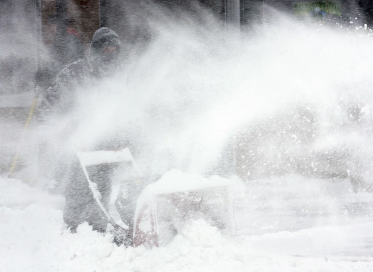 In this photo from Sunday, Ryan Luken clears a sidewalk in north Fargo, N.D.