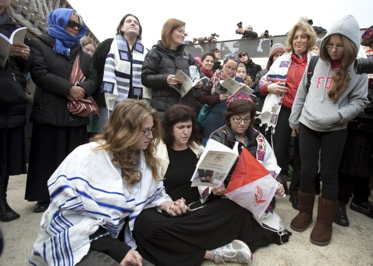 Susan Silverman (C), a reform rabbi sits on the ground and prays with her daughter (L) after being asked by Israeli police to remove their prayer shawls at the Western Wall in Jerusalem's Old City on Monday. Israeli police detained the two and eight other women on Monday for wearing prayer shawls, which Orthodox tradition sees as solely for men, a spokesman said. Susan Silverman is the sister of American comedian Sarah Silverman.