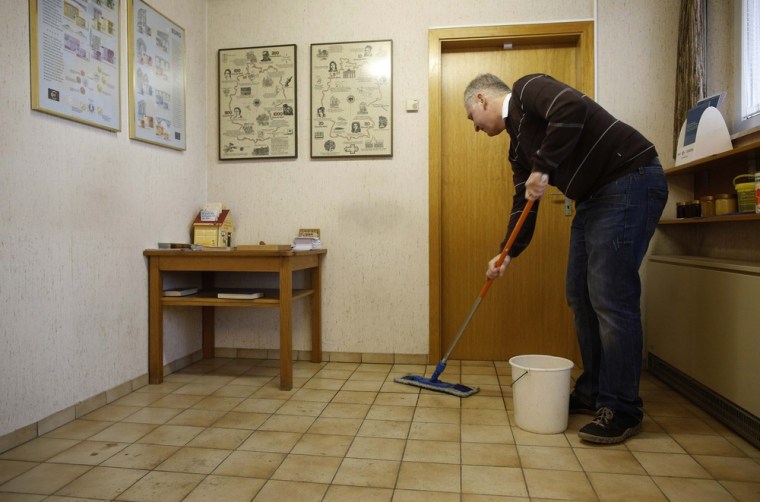 Peter Breiter washes the floor in the waiting room of the bank.