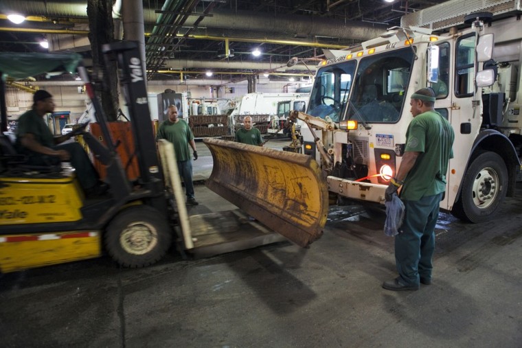 Department of Sanitation workers attach plows to garbage trucks in preparation for Hurricane Irene as the storm approaches New York on Saturday, Aug. 27.